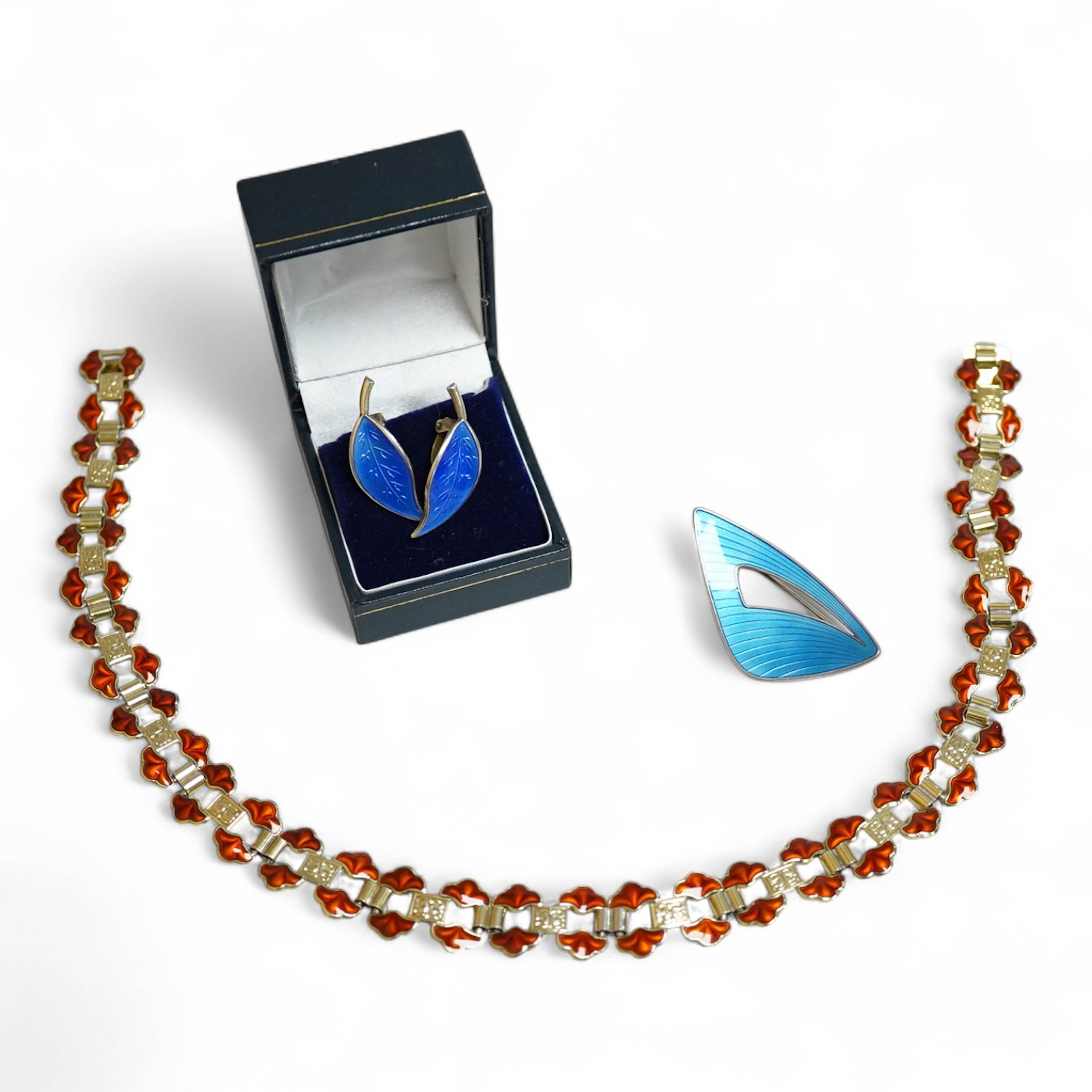 A pair of Norwegian gilt sterling and blue enamel ear clips by David Andersen, 31mm, together with one other Norwegian 925S and blue enamel free form brooch, 47mm and a gilt 925S and red enamel set necklace, 39.5cm.